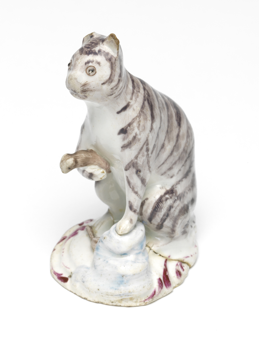 Seated cat holding a trapped mouse